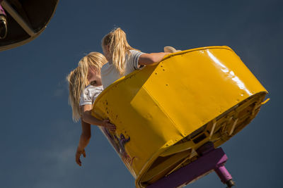 Low angle view of woman against yellow sky