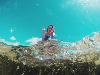 Portrait of woman gesturing seen through sea water