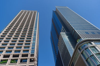 Low angle view of modern buildings against clear blue sky