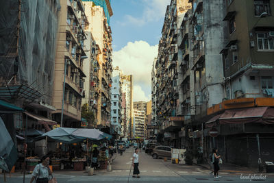 People walking on street amidst buildings in city