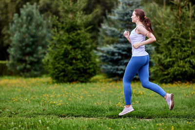 Full length of woman running on grass