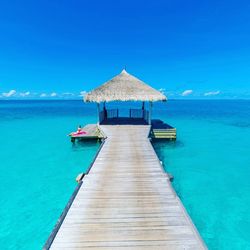 Pier over sea against blue sky