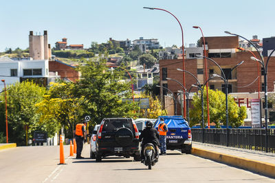 Cars on street by buildings against sky