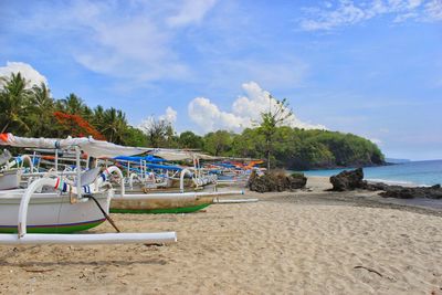 Boats moored on beach against sky