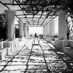 Rear view of person walking on footpath amidst buildings