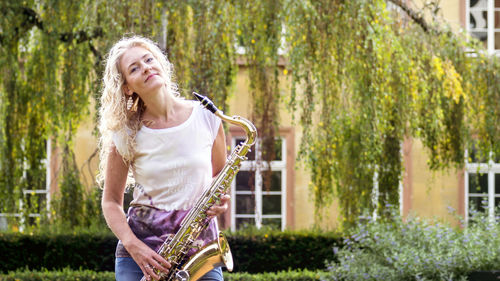 Full length of woman standing by tree