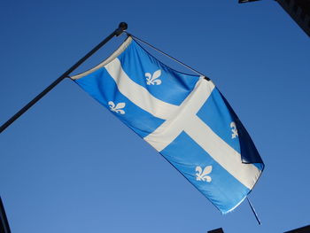 Low angle view of flags against clear blue sky