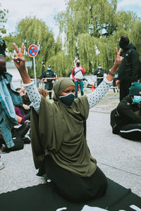 Rear view of people sitting on road