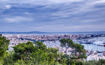 High angle view of townscape by sea against sky