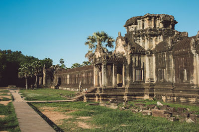 View of old ruined temple against clear blue sky during sunny day