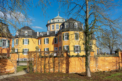 Bare trees and buildings against sky