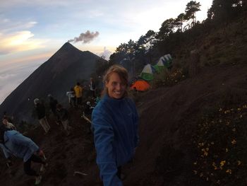 Portrait of smiling boy standing on mountain against sky
