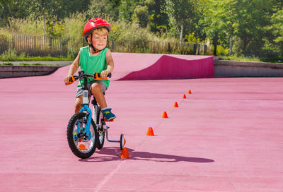 Portrait of boy riding bicycle on road