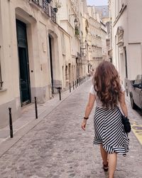 Rear view of woman walking on street in city