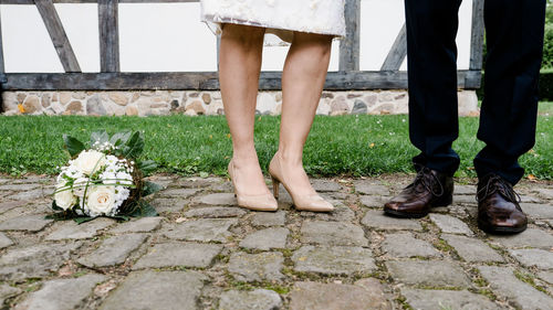 Low section of couple standing on footpath