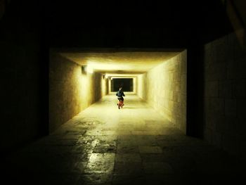 Full length of woman walking in tunnel