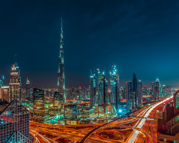 Illuminated cityscape against sky at night