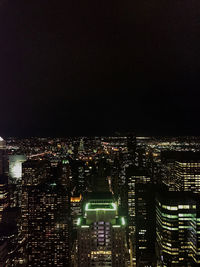 Illuminated cityscape against sky at night