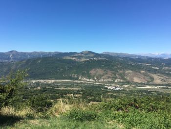 Scenic view of field against clear blue sky