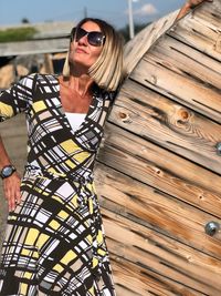 Smiling woman standing by wooden structure