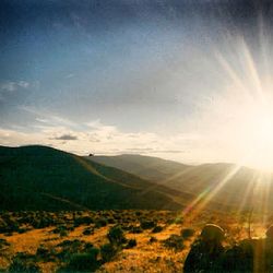 Sun shining through clouds over mountains