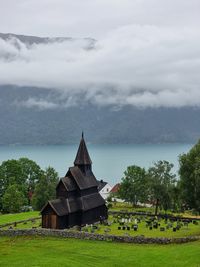 Rear view of woman standing by sea against sky