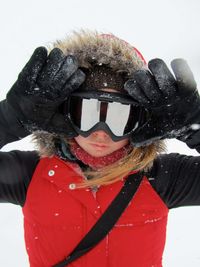 Girl gesturing in ski-wear on snowfield