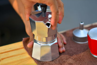 Close-up of hand holding drink on table