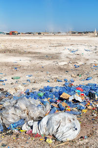 Garbage on sand at beach against clear sky