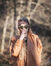 Young woman wearing sunglasses while standing outdoors