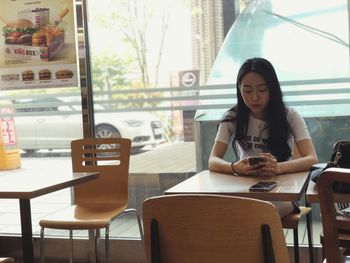 Young woman sitting on table in restaurant