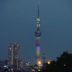 Illuminated skyscrapers against clear sky at night