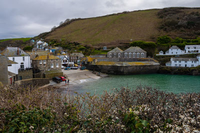 Scenic view of townscape by mountain against sky