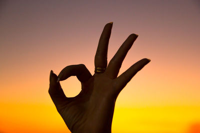 Silhouette person against orange sky during sunset