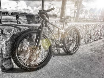 Bicycle by tree against sky
