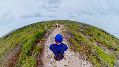 Full length rear view of man on mountain against sky