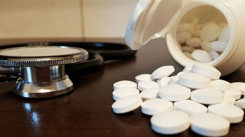 Close-up of stethoscope and pills on table