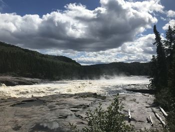 Scenic view of waterfall against sky