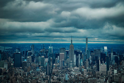 Modern buildings in city against cloudy sky