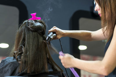 Rear view of young woman working at home