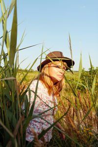 Outdoor portrait of beautiful young blonde woman near reed and pampas grass. plant art shadows. 