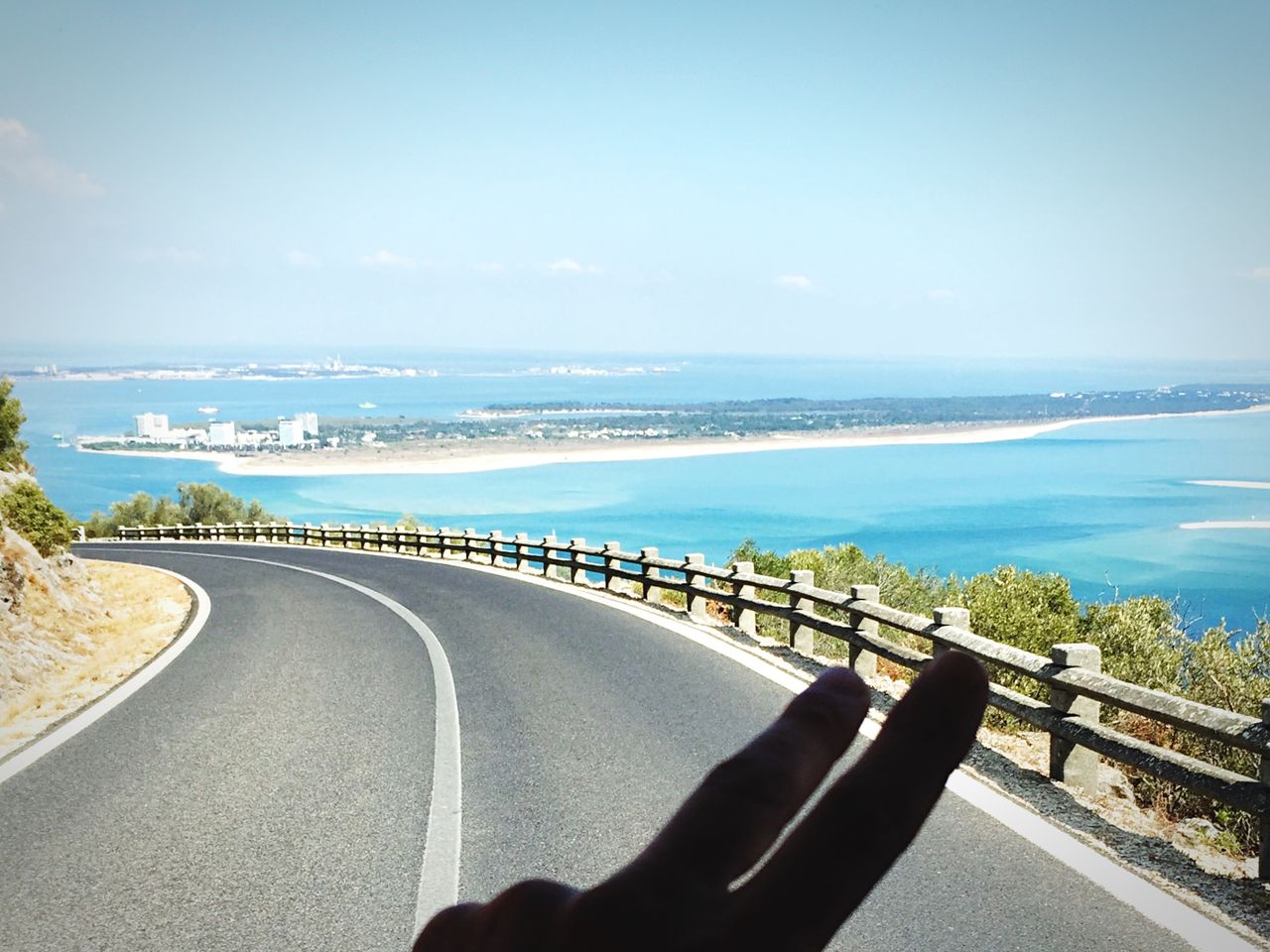 sea, the way forward, transportation, horizon over water, road, water, diminishing perspective, sky, tranquil scene, blue, clear sky, road marking, tranquility, railing, scenics, vanishing point, beach, copy space, long, empty