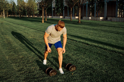 Full length of man with arms raised on grass