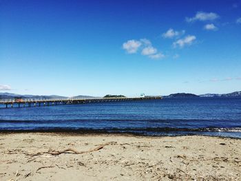 Scenic view of beach against blue sky