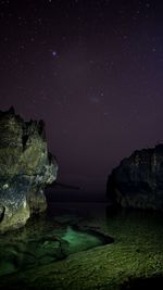 Scenic view of rock formation at angels billabong on nusa penida with beautiful night sky and stars 