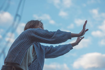 Low angle view of woman dancing against sky