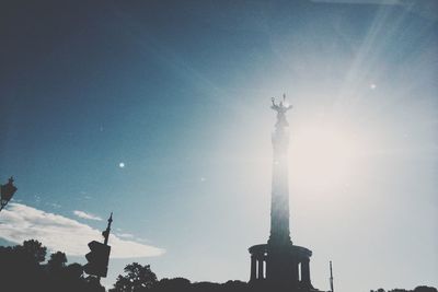 Low angle view of sun shining through clouds