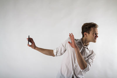 Young man looking away against white background