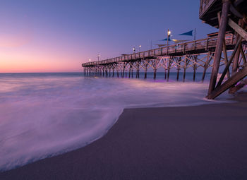 Pier over sea against sky during sunset