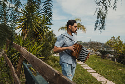 Side view of woman sitting on railing